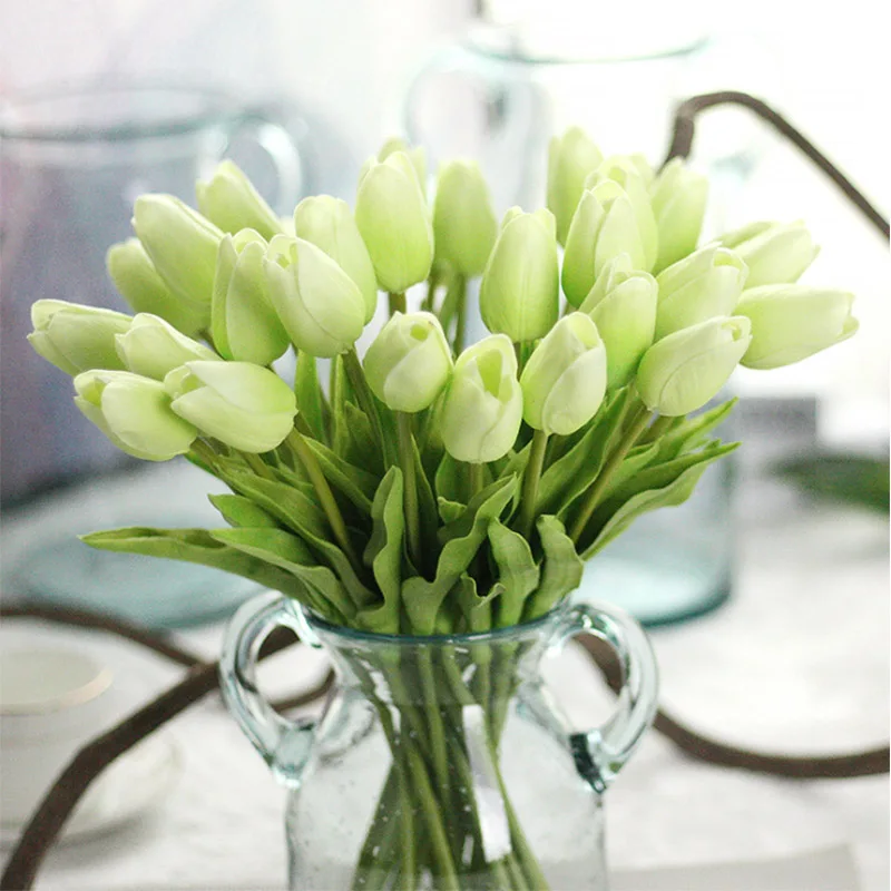 Elegant bouquet of white tulips in glass vase.