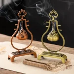 Elegant incense holders with smoke on a table.