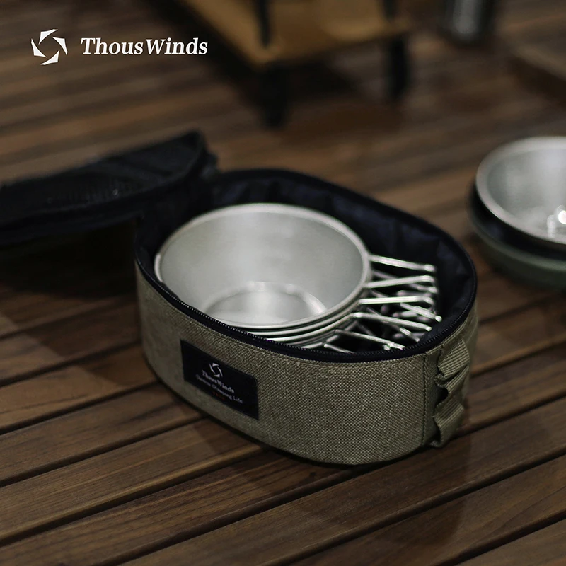 Camping cookware set on wooden surface