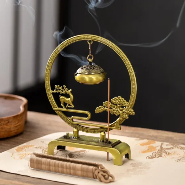 Brass incense holder with decorative deer and tree design.