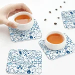 Tea cups on science-themed coasters.