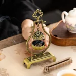 Ornate incense burner with coils and teapot nearby.