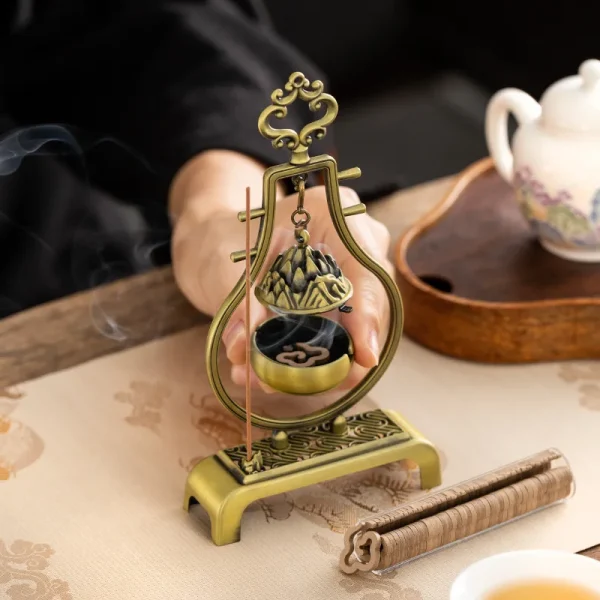 Ornate incense burner with coils and teapot nearby.